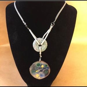 Round copper pendant attached to lt gr stone disc